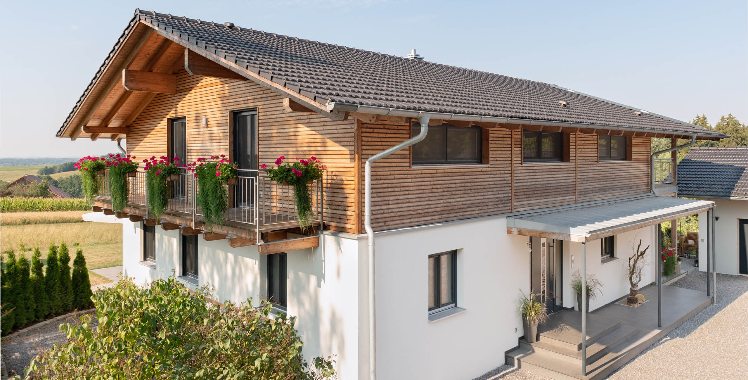 Holzfassade und verputzte Fassade von Schwarz & Sohn
